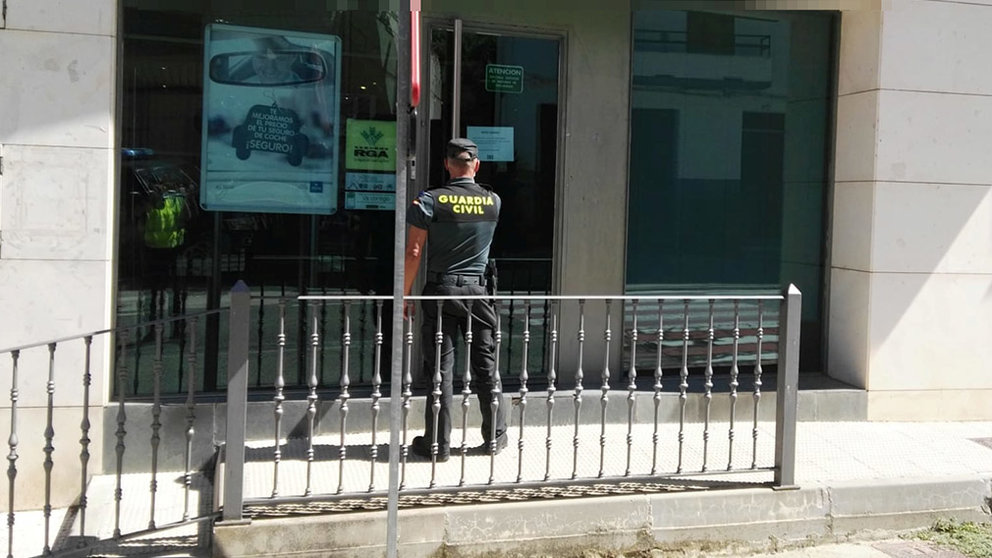 Un agente en la sucursal bancaria de la merindad de Sangüesa donde se produjo el hurto de 5.000 euros. GUARDIA CIVIL
