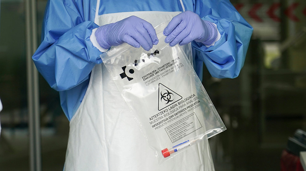 Un sanitario protegido con guantes sostiene una bolsa en la que hay una muestra para realizar un Análisis PCR. ARCHIVO