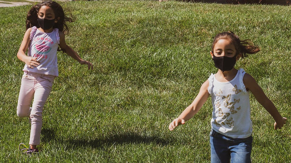 Dos niñas corren por el campo. ARCHIVO