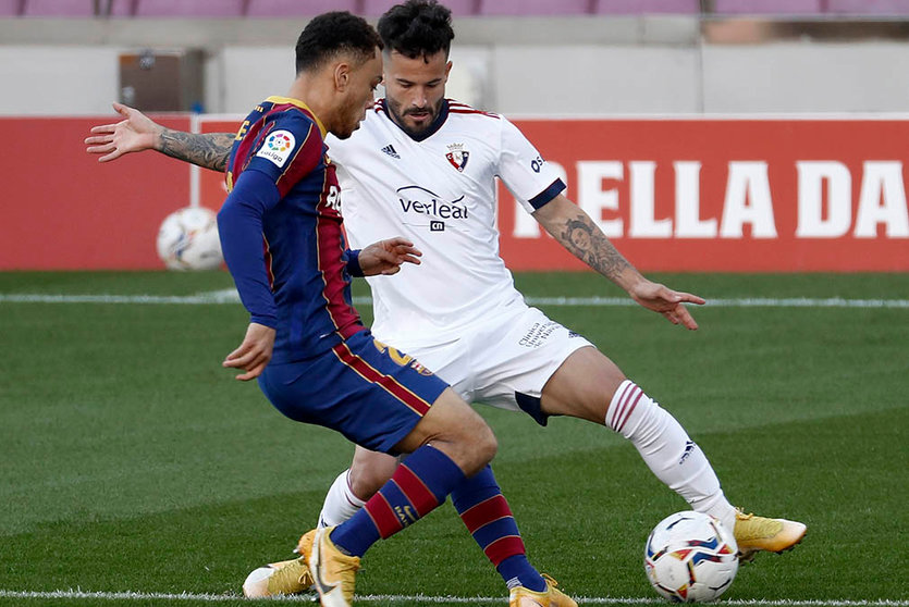 El  jugador del Osasuna Rubén García (d) intenta controlar el balón ante la presencia de Sergiño Dest (i), del Barcelona, durante el partido de la úndecima jornada de la Liga de Primera División disputado este domingo en el Camp Nou. EFE/ Andreu Dalmau