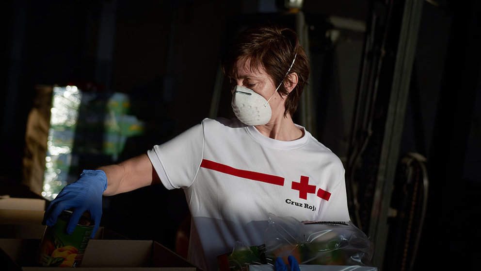 Voluntario de Cruz Roja preparando un bote de comida. CRUZ ROJA
