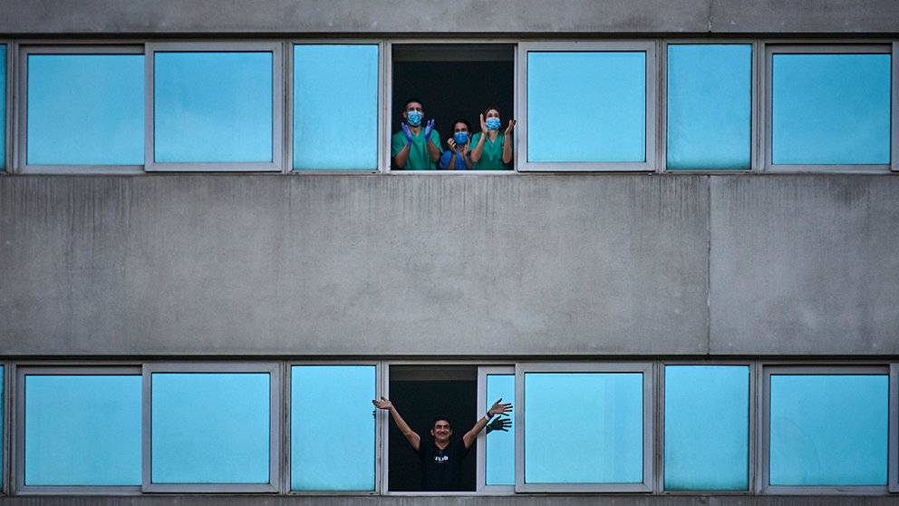 El hotel NH Irauña Park se habilitó como hospital para albergar a los contagiados de covid menos graves, en la imagen tomada el 17 de abril, una persona contagiada saluda por la ventana mientras 3 sanitarios aplauden a las 8 de la tarde. PABLO LASAOSA