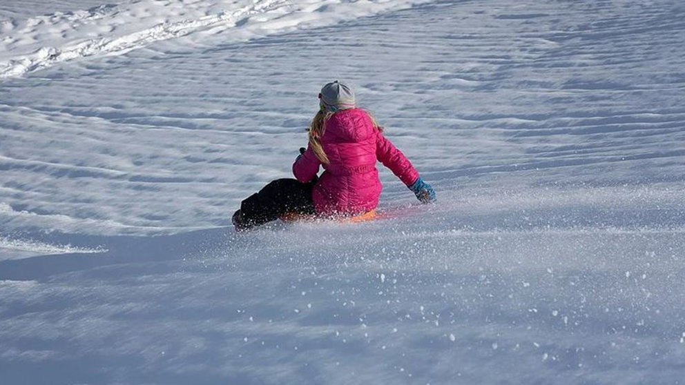 Una niña se tira con su trineo por una cuesta cubierta de nieve ARCHIVO