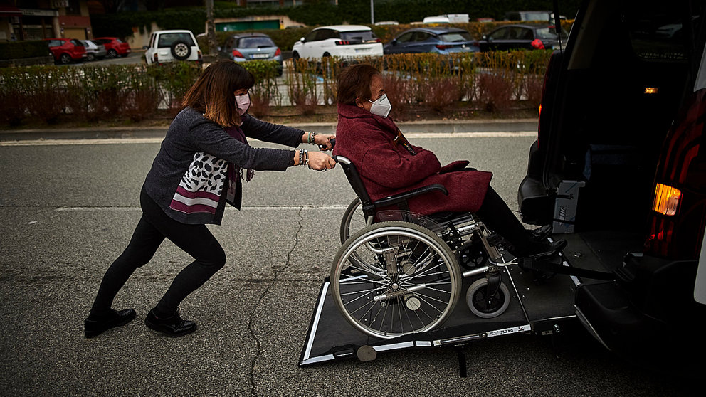 Persona en silla de ruedas ayudada por un ciudadano. PABLO LASAOSA