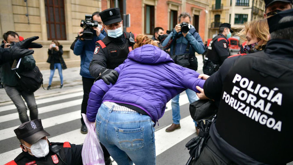Agentes de la Policía Foral y feministas forcejean durante una manifestación frente al Parlamento de Navarra durante el 8-M. PABLO LASAOSA