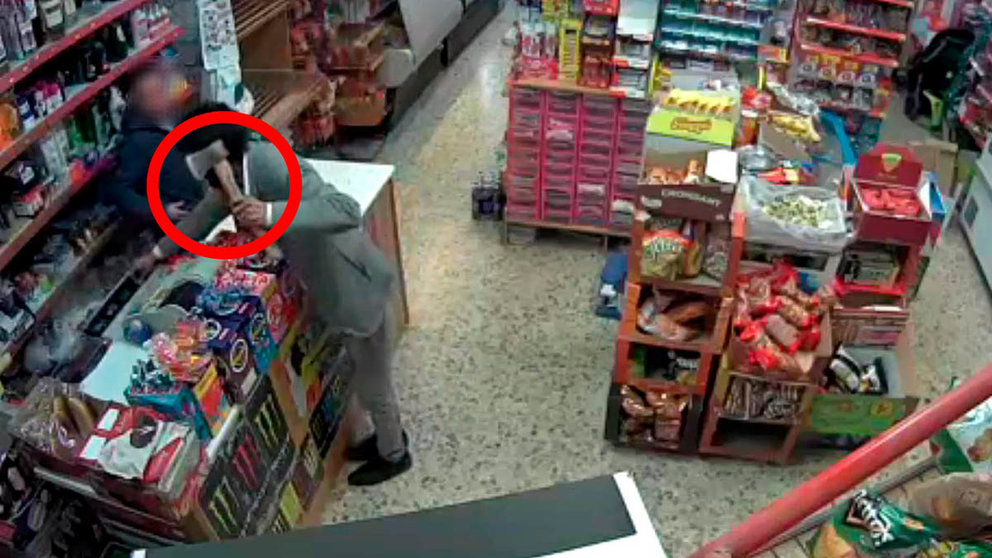 Imagen captada por las cámaras de seguridad del comercio en Lodosa en la que se ve al atracador amenazando con un hacha al comerciante. GUARDIA CIVIL