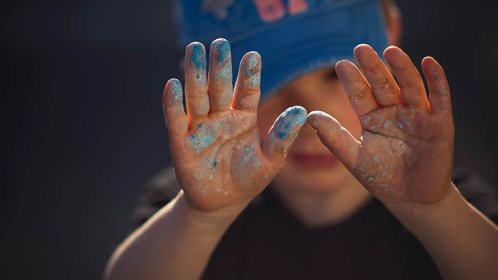 Un niño muestra sus manos manchadas de pintura. ARCHIVO