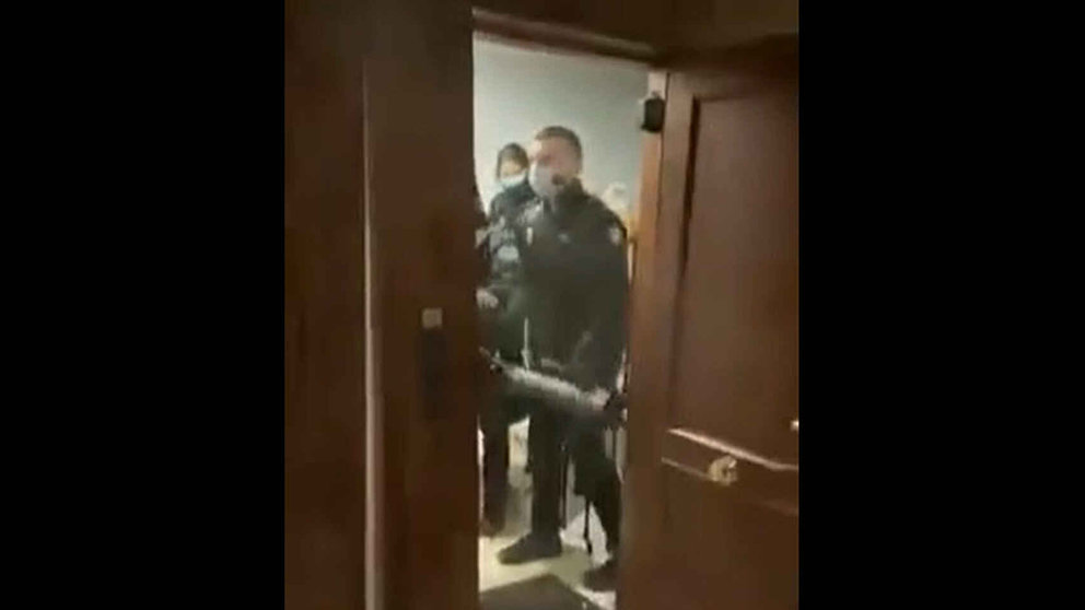 Agentes de la Policía Nacional tras tirar la puerta abajo de una vivienda donde había una fiesta con 9 personas.