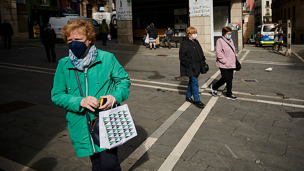 Varias personas caminan por la Plaza del Ayuntamiento de Pamplona con mascarilla para evitar propagar el coronavirus. PABLO LASAOSA