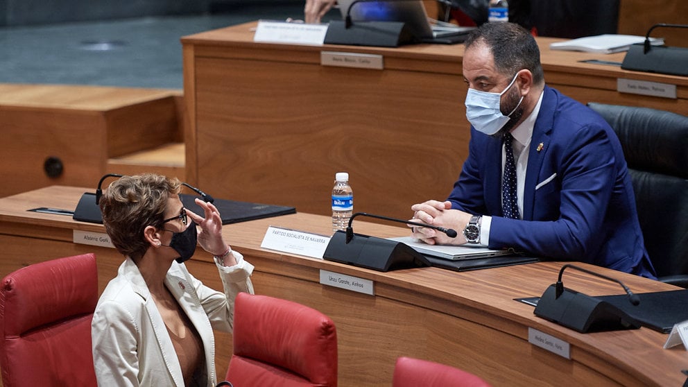 La presidenta del Gobierno de Navarra, María Chivite, habla con el portavoz socialista, Ramón Alzorriz, durante la sesión plenaria de los jueves. MIGUEL OSÉS