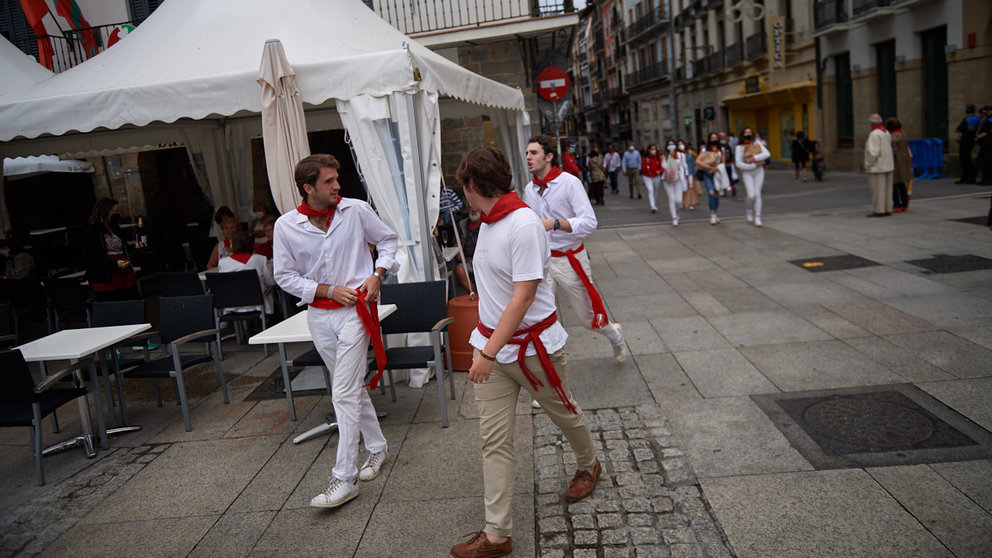 Tres personas vestidas de blanco caminana por la Plaza del castillo de Pamplona durante los no sanfermines de 2021. MIGUEL OSÉS
