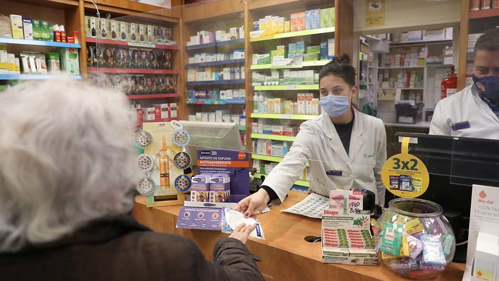 Una anciana recoge una mascarilla FFP2 en una farmacia. Marta Fernández / Europa Press