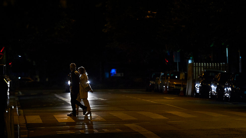 Dos personas cruzan un paso de peatones minutos antes del toque de queda impuesto hasta septiembre. PABLO LASAOSA