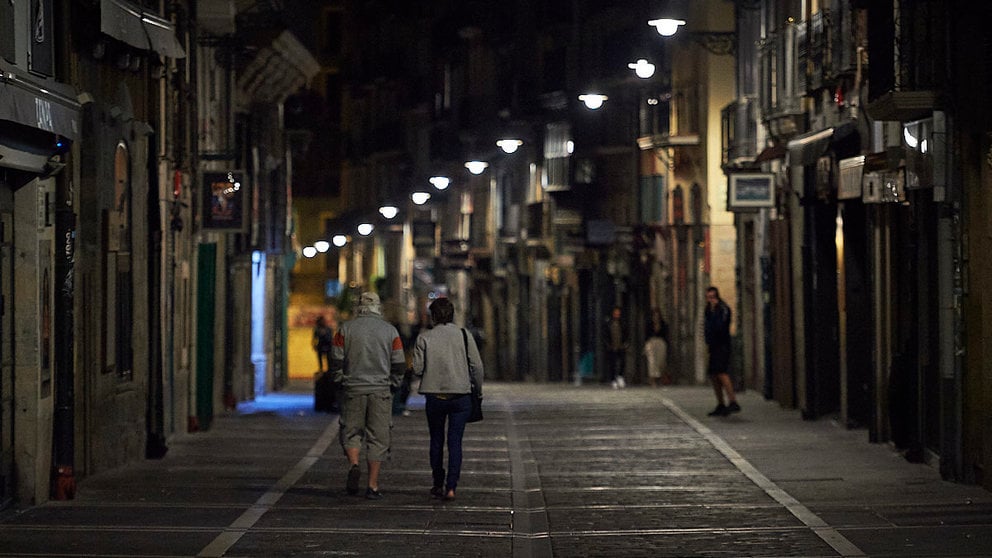 Varias personas caminan por la calle Estafeta de Pamplona minutos antes del toque de queda impuesto hasta septiembre a causa de la quinta ola del coronavirus. PABLO LASAOSA