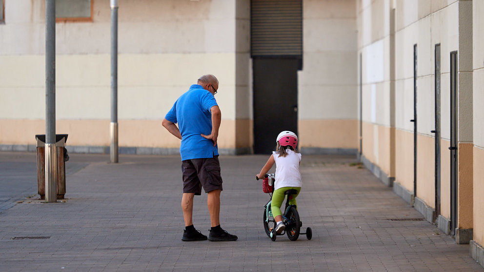 Un abuelo y su nieta pasean por la calle en los últimos días de verano de 2021 durante la crisis del coronavirus en la Comunidad Foral. MIGUEL OSÉS