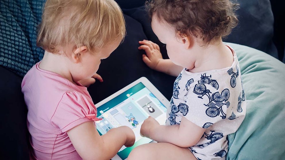 Dos bebés juegan con una tablet. ARCHIVO