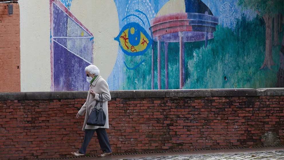 Una señora cruza la Plaza de los Fueros de Pamplona tras la recuperación de la obligatoriedad del uso de las mascarillas en exteriores. IÑIGO ALZUGARAY