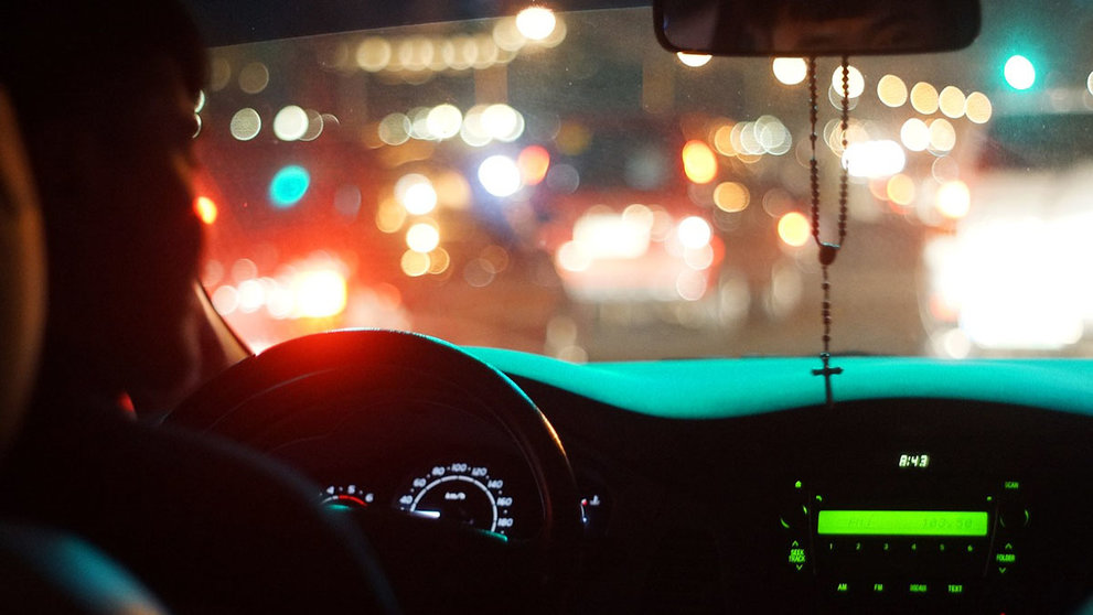 Una persona conduce un coche por la noche en un vía iluminada. ARCHIVO