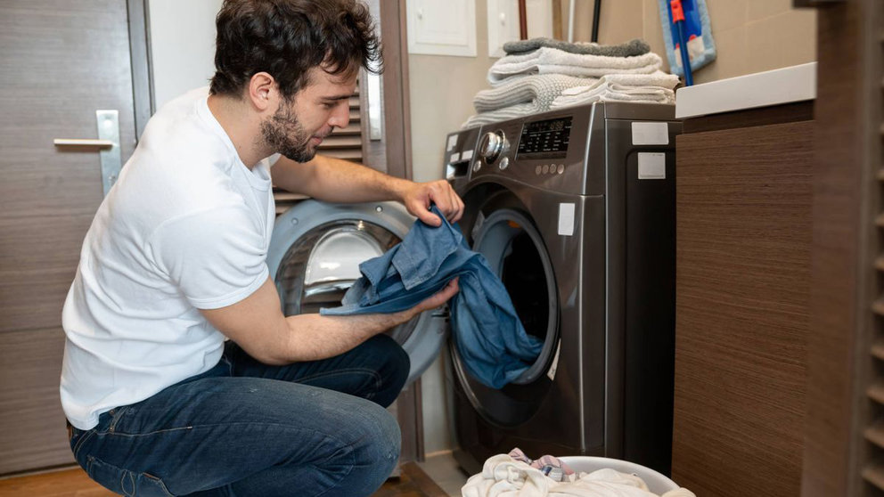 Un hombre se encarga de poner una lavadora. ISTOCK