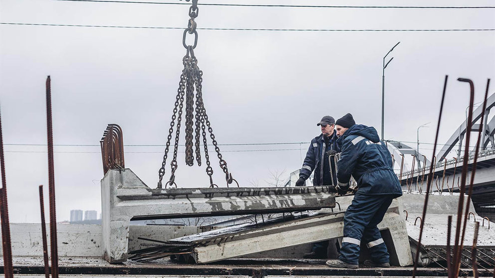 Dos operarios cargan losas de cemento para cortar la carretera, a 2 de marzo de 2022, en Kiev (Ucrania). - Diego Herrera - Europa Press