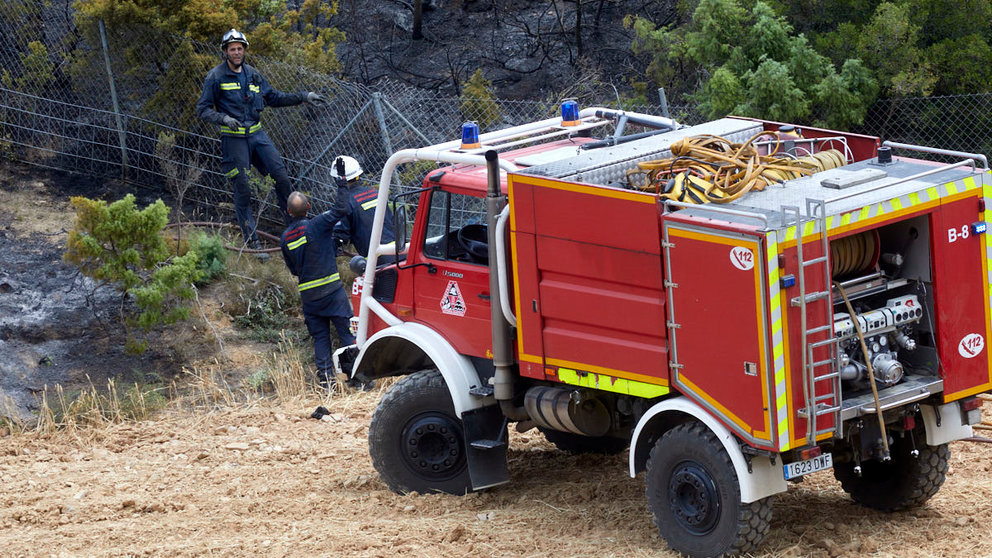 Un retén de bomberos trabajan en la extinción y control del incendio de la sierra del Perdón. IÑIGO ALZUGARAY