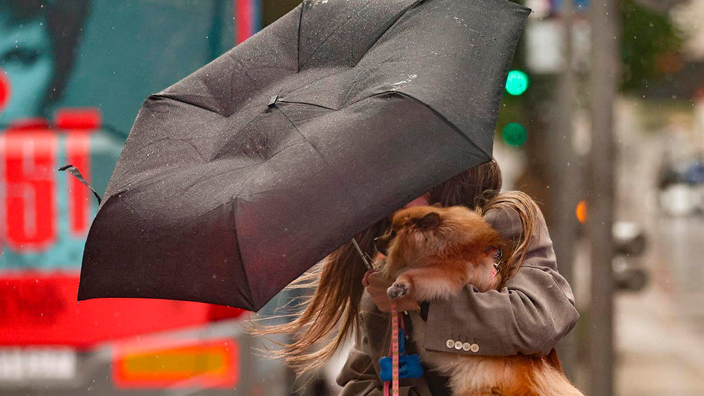 Una mujer se protege del viento con un paraguas. - Eduardo Parra - Europa Press