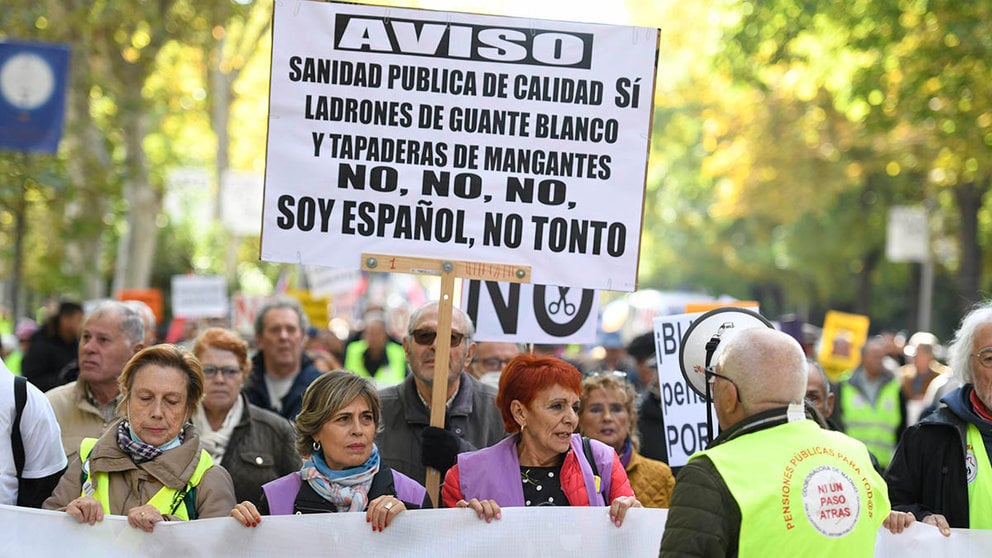 Varias personas sostienen carteles y una pancarta durante la manifestación celebrada este sábado en Madrid para rechazar la "privatización y los recortes" en los servicios públicos y reclamar la subida de las pensiones y salarios al Índice de Precios al Consumo (IPC) "real". EFE/Víctor Lerena
