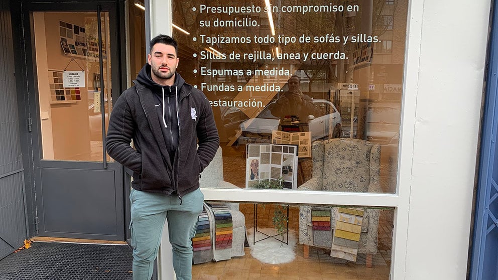 Bryan Jiménez Martínez junto al escaparate de la Tapicería Javier en Pamplona. Navarra.com