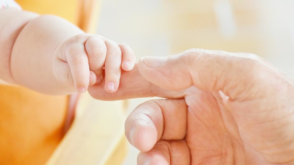 Una persona ofrece su mano a un bebé. ARCHIVO