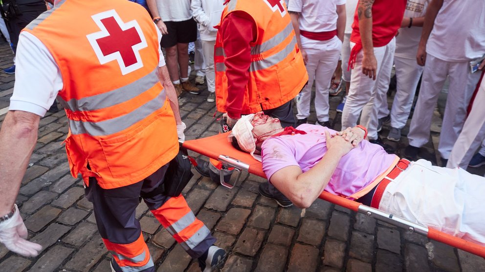 Dos sanitarios llevan en camilla a un herido en el cuarto encierro de las fiestas de San Fermín 2023, a 10 de julio de 2023, en Pamplona. EDUARDO SANZ / EUROPA PRESS