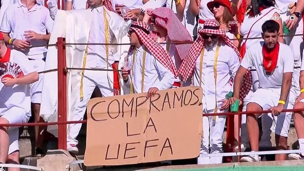 Unos 'jeques' con un cartel de 'Compramos la UEFA' en la plaza de toros de Pamplona en la corrida de Fuente Ymbro en San Fermín.