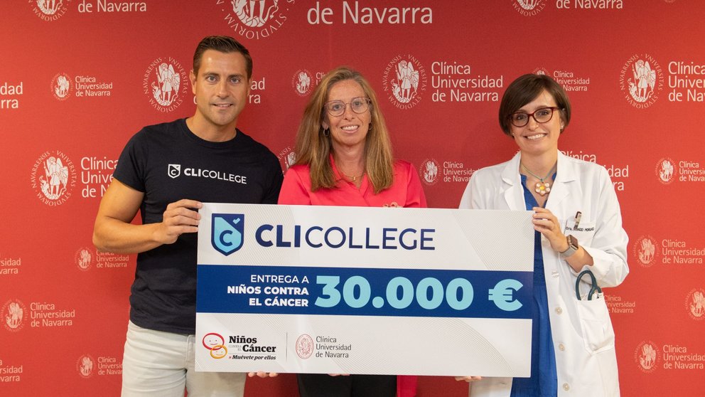 Pablo Fernández entrega el cheque de 30.000 euros a Pilar Lorenzo, responsable de RSC de la Clínica Universidad de Navarra, entre profesionales sanitarios, pacientes y familiares. CEDIDA