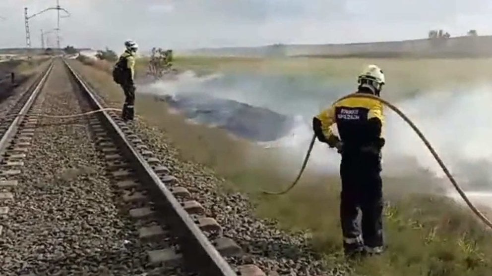 Los bomberos se afanan en la extinción de las llamas junto a las vías del tren. BOMBEROS DE NAVARRA