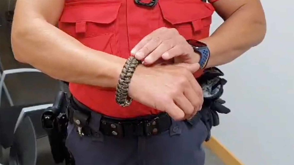 Un agente de la Policía Foral muestra la pulsera intervenida a un detenido. POLICÍA FORAL