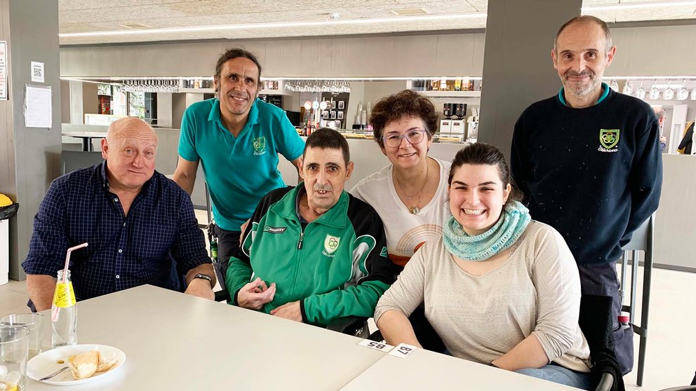 Manuel Guembe, sentado con chandal verde, con su familia y amigos en el bar de Oberena en marzo de 2023. Navarra.com