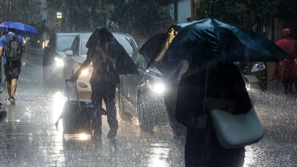 Varias personas se resguardan bajo un paraguas de la lluvia, el viento y el mal tiempo. ROBER SOLSONA / EUROPA PRESS