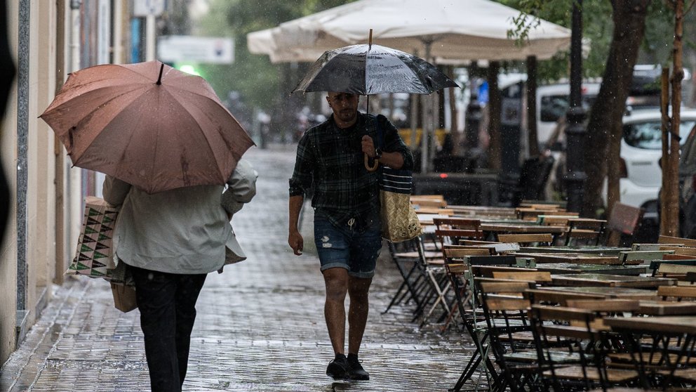 Varias personas se resguardan bajo un paraguas de la lluvia, el viento y el mal tiempo. DIEGO RADAMÉS / EUROPA PRESS