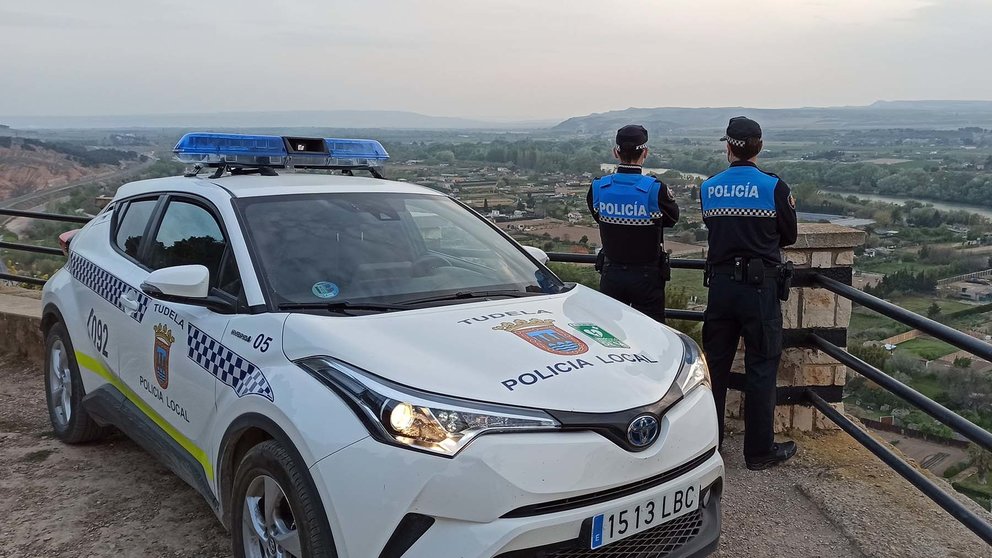 Dos agentes de la Policía Municipal de Tudela junto a un coche patrulla. ARCHIVO