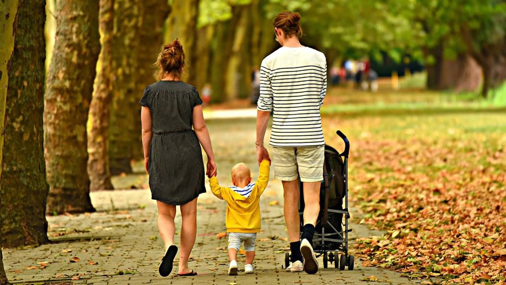 Una pareja pasea con su hijo por el parque. ARCHIVO