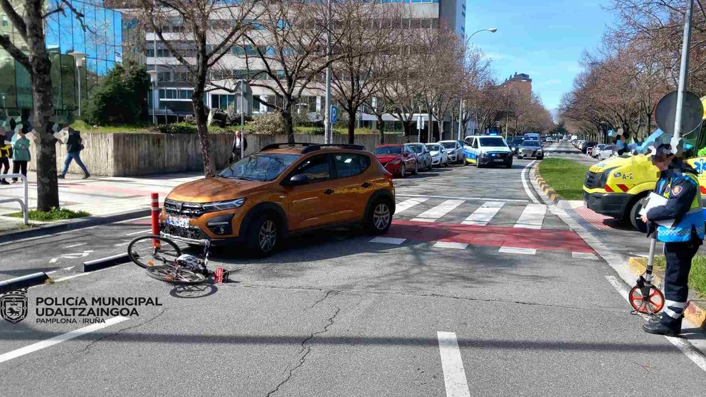 La bici siniestrada y el coche que la arrolló sobre el carril bici que cruza la calle Arcadio María Larraona en la rotonda de los Golem de Pamplona. POLICÍA MUNICIPAL DE PAMPLONA